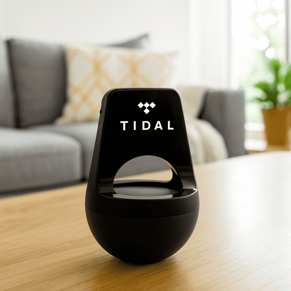 A black wireless speaker made from recycled ABS, featuring a logo, placed on a wooden table in a living room setting.