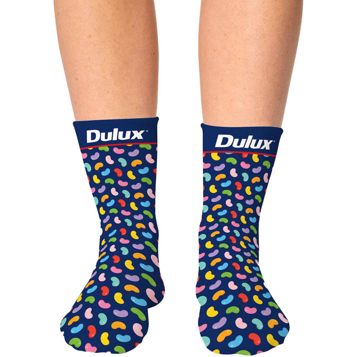 Colourful patterned socks with a navy background, featuring a playful design of multicoloured shapes and a logo on the cuff.