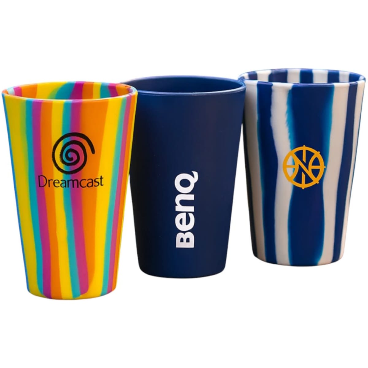 Three tumblers in vibrant colours: one with stripes, one solid navy, and one with a blue and white swirl pattern, featuring logos.