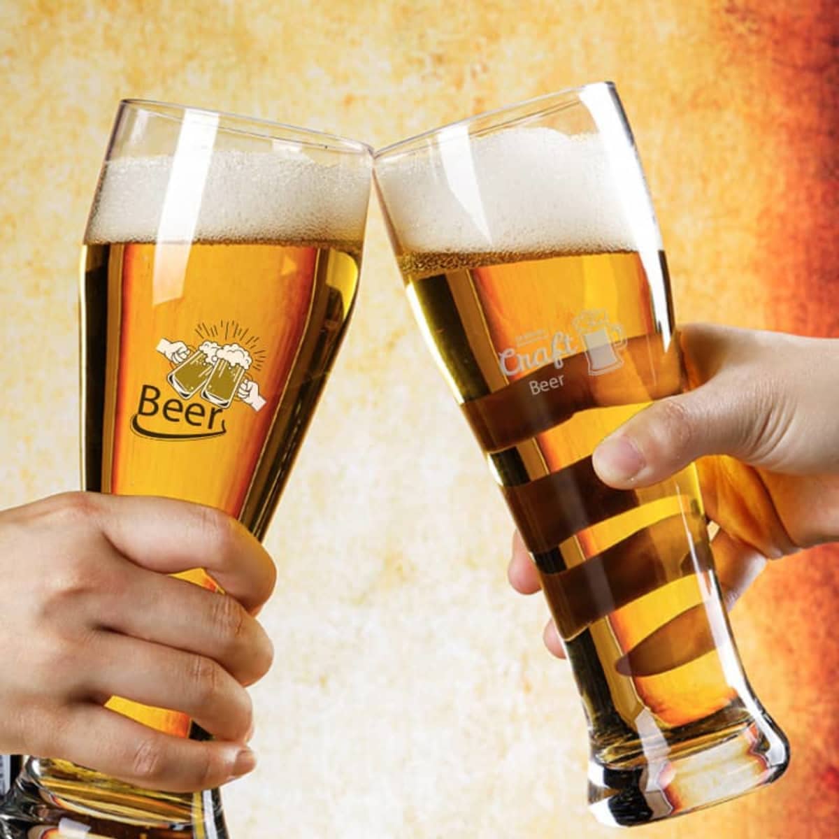 Two clear pint beer glasses filled with golden beer and foamy tops, clinking together. Each glass has a logo.