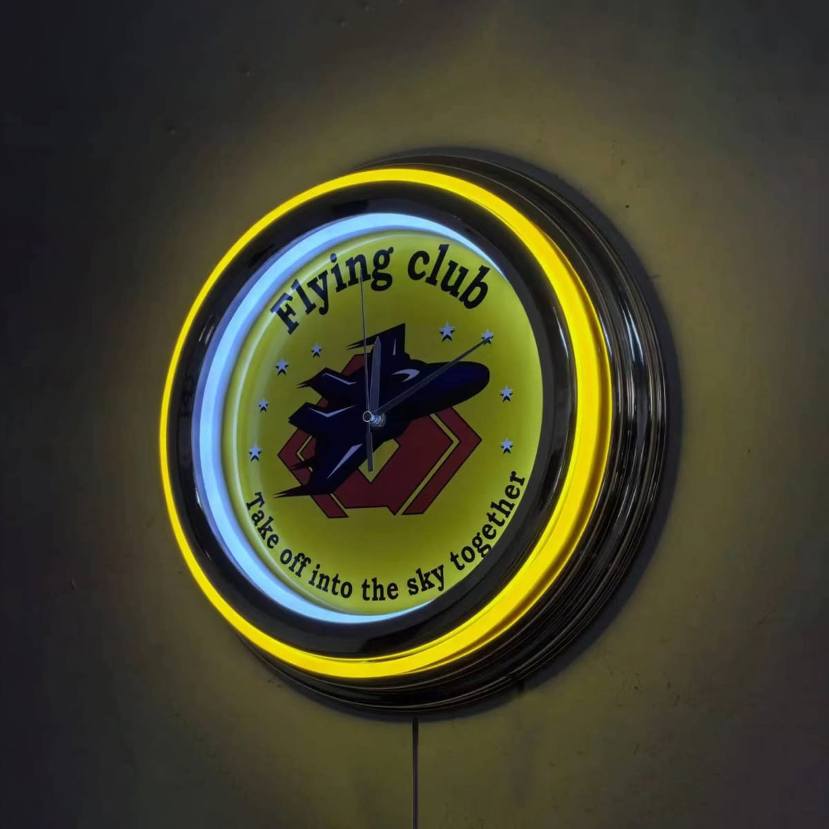 A round neon wall clock featuring yellow and black colours, with a flying club theme and a logo.