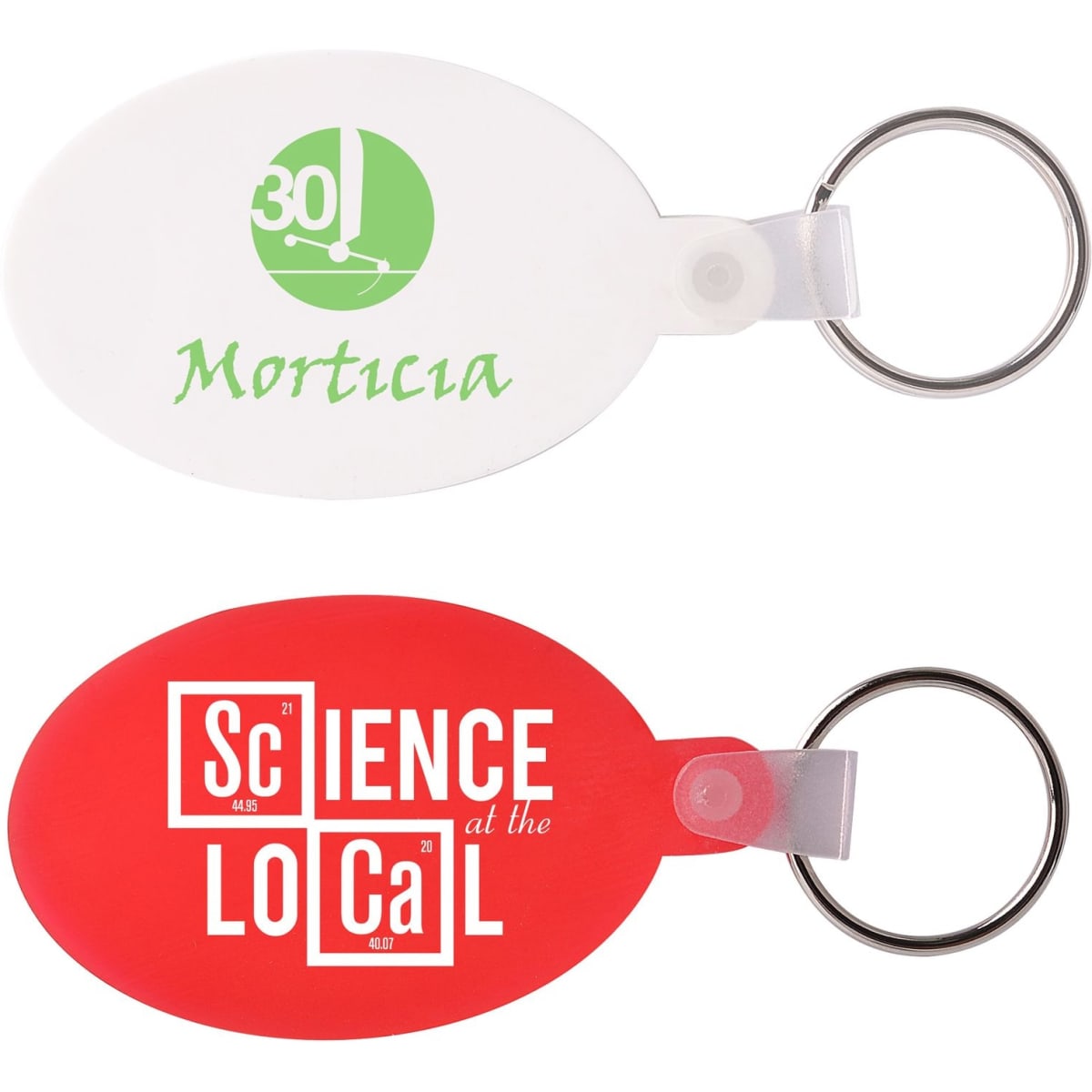 Two oval keyrings: one white with green text and one red with white text. Both have a metal ring attachment.