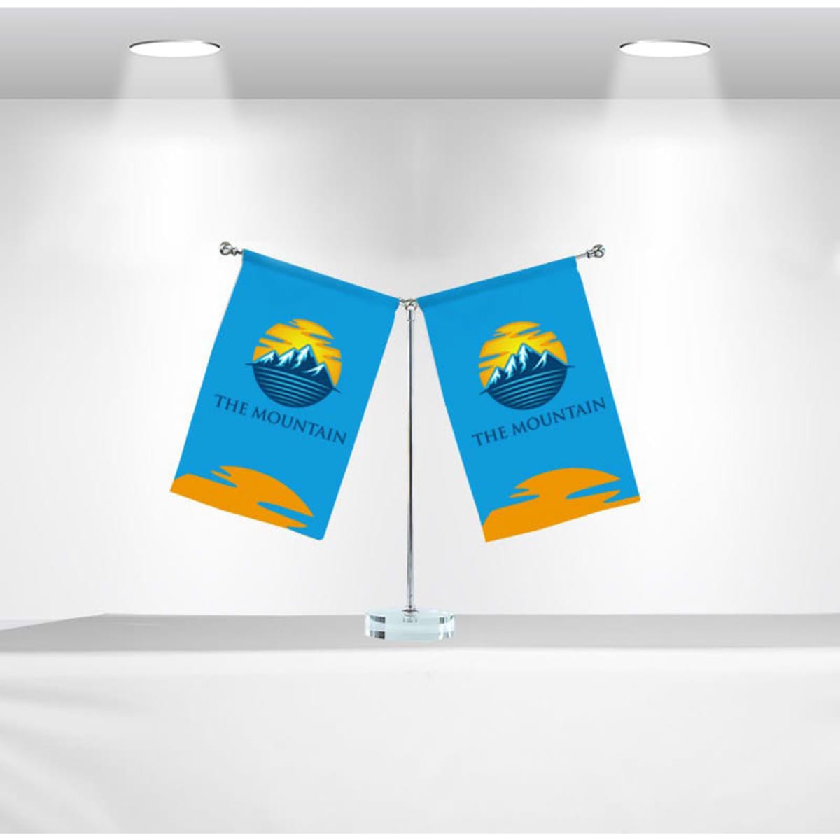 Two blue desk flags on a silver pole, featuring a logo and set against a bright background.