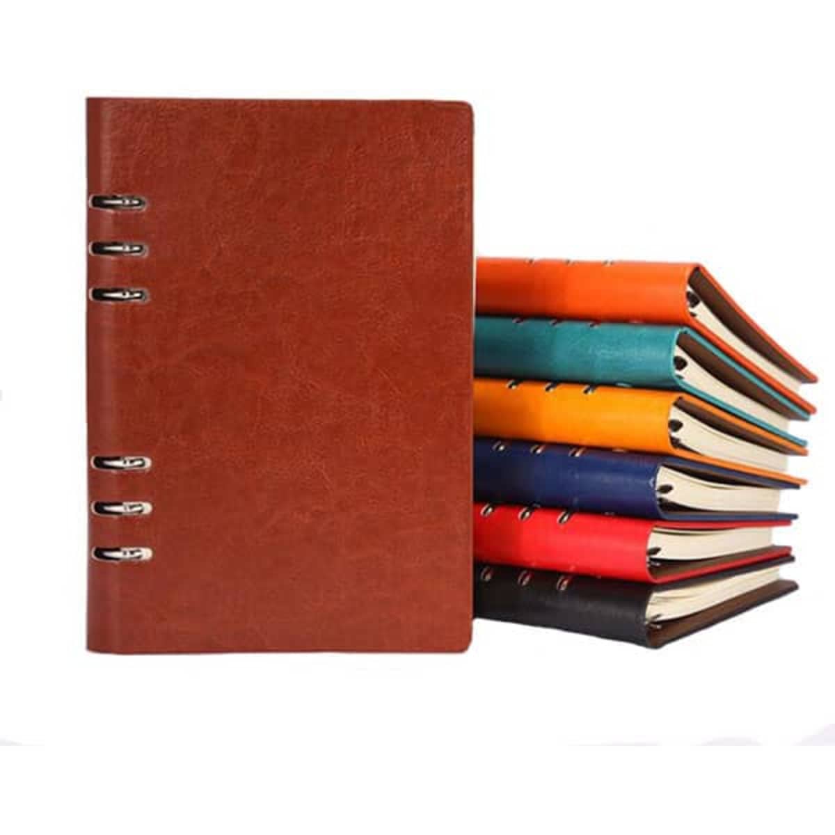 A brown PU leather spiral notebook with several colourful notebooks stacked behind it. Each notebook has a different colour.