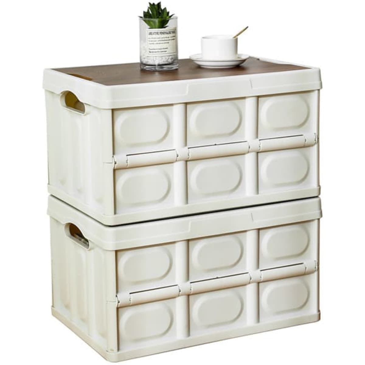 A stack of white folding storage bins with a wooden top, holding a cup and a small plant.