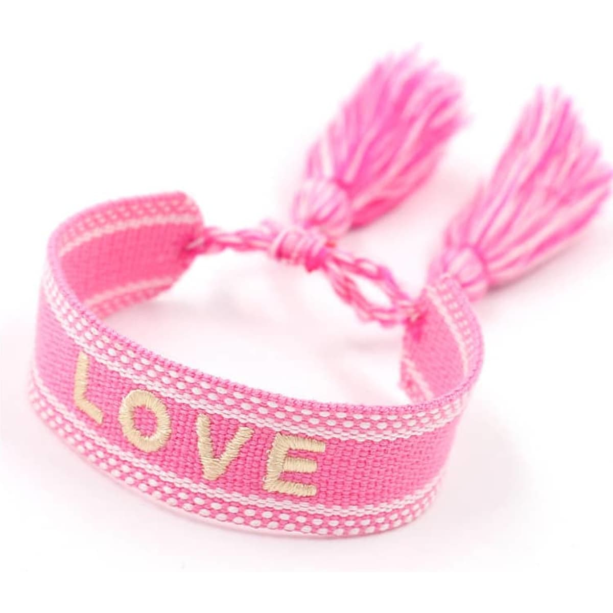 A pink adjustable knitted bracelet with gold lettering spelling "LOVE" and two tassels on each end.