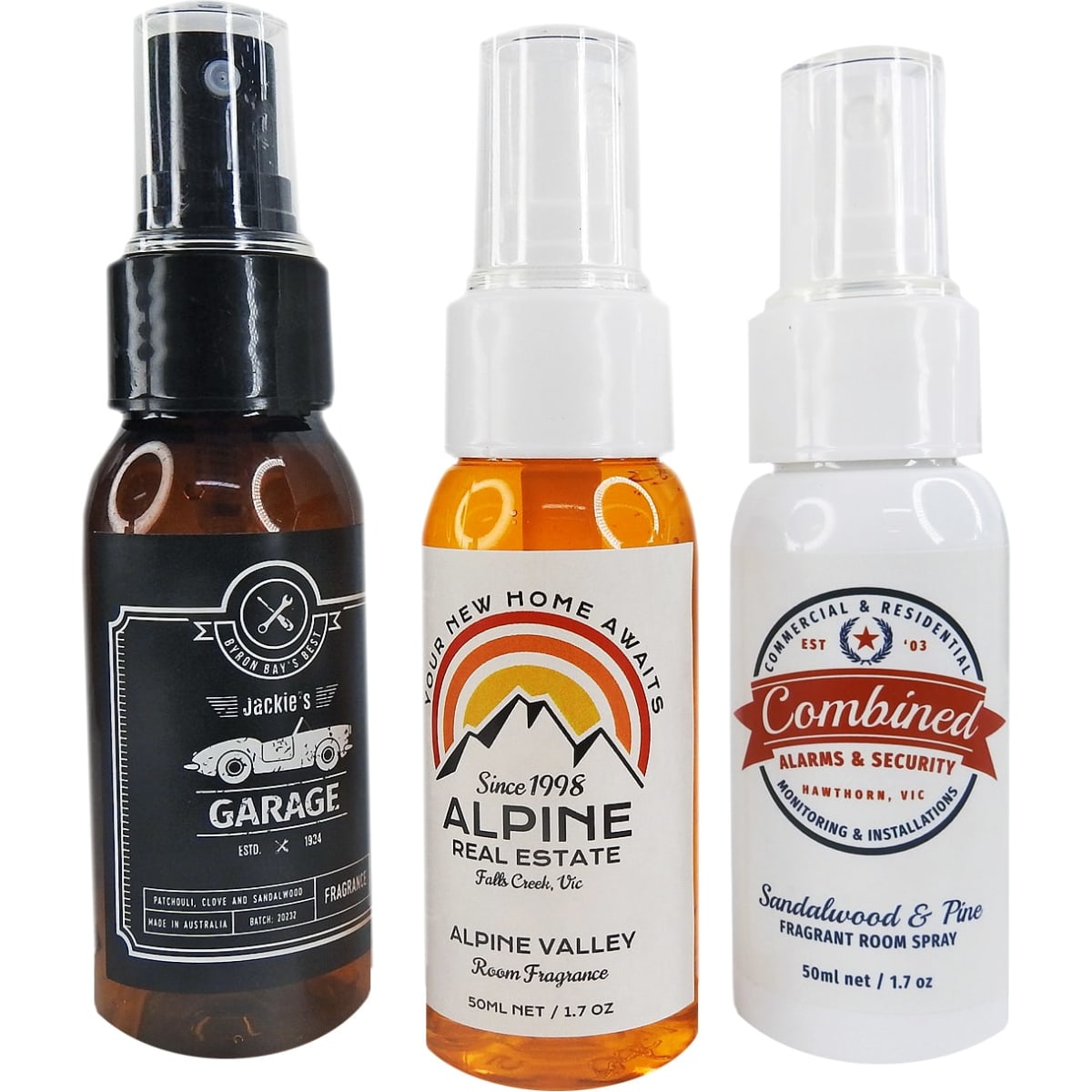 A selection of three room fragrance bottles in black, amber, and white, featuring different designs and a logo on each.
