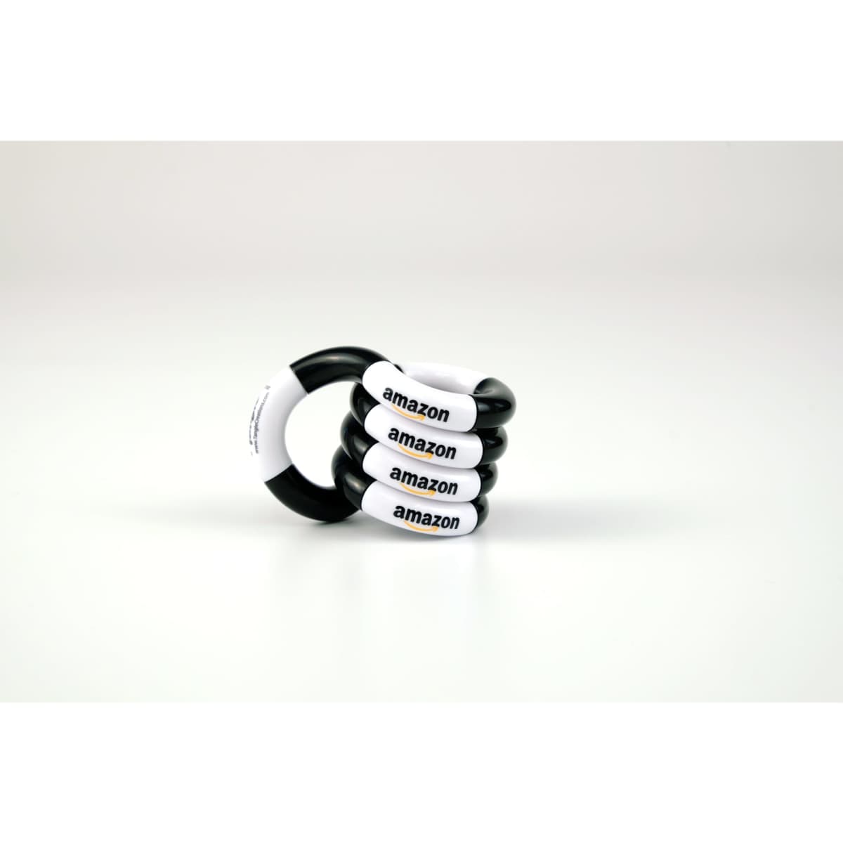 A set of four black and white Tangle toys featuring branding on each piece.