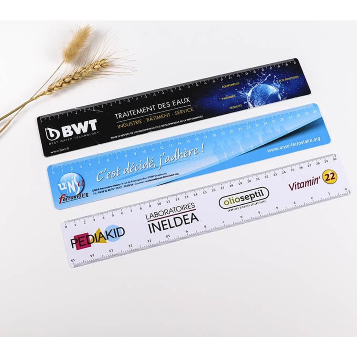 Three flexible rulers in blue and white, each with different designs and branding, measuring 310 x 40mm.