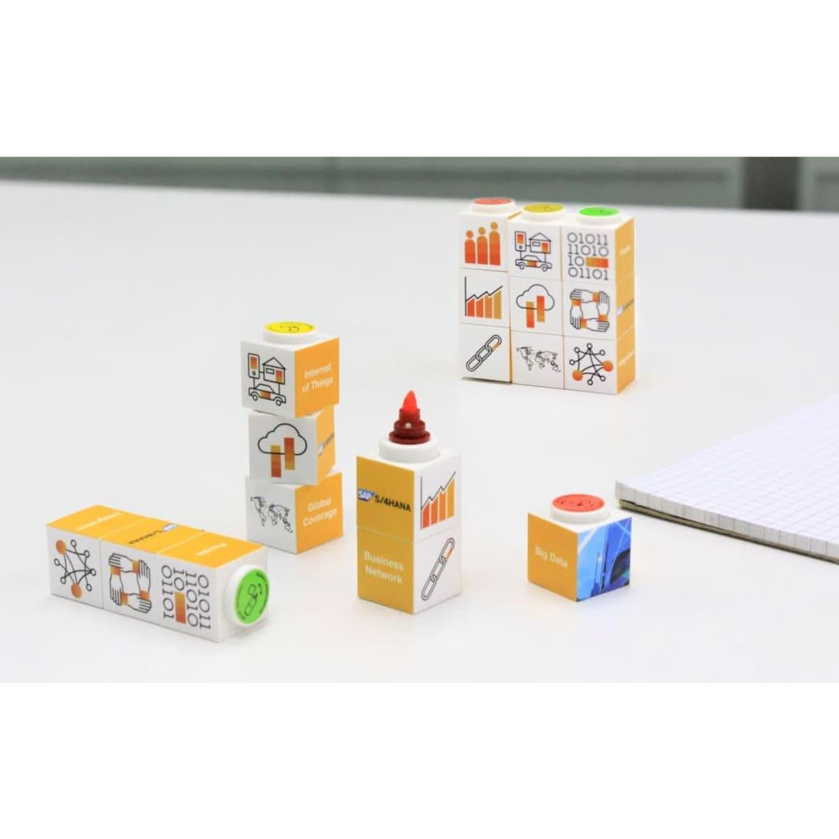 A set of brightly coloured highlighters in various shapes, including orange, green, and red, with branding visible.