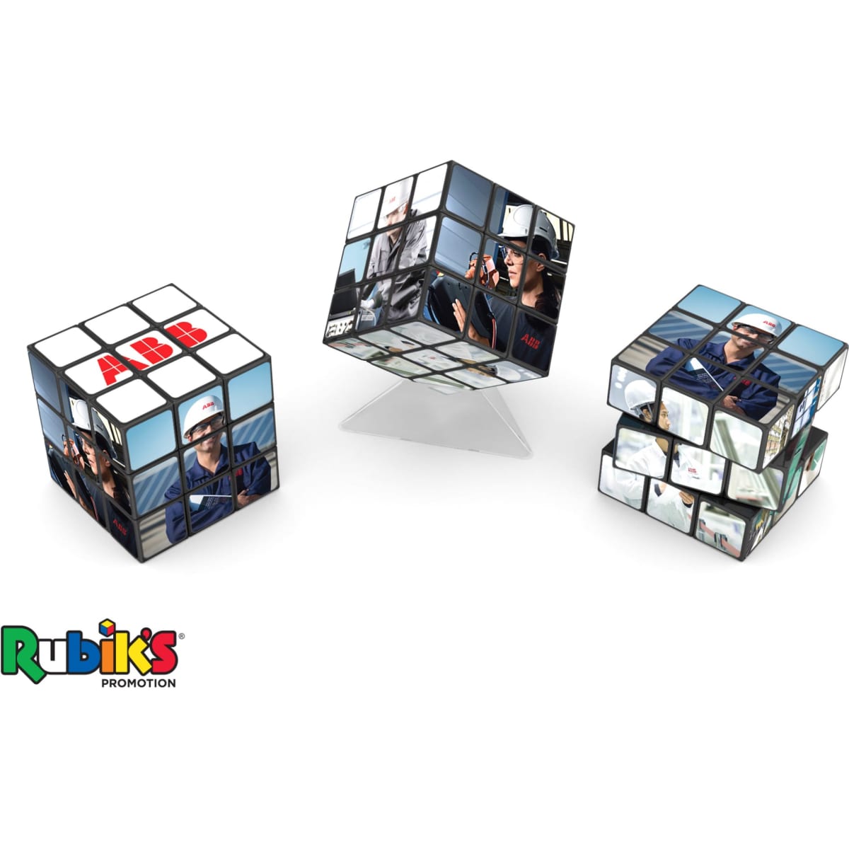 A Rubik's Cube 3x3 (57mm) features mixed images and a logo, with a classic multicolour design displayed on a stand.