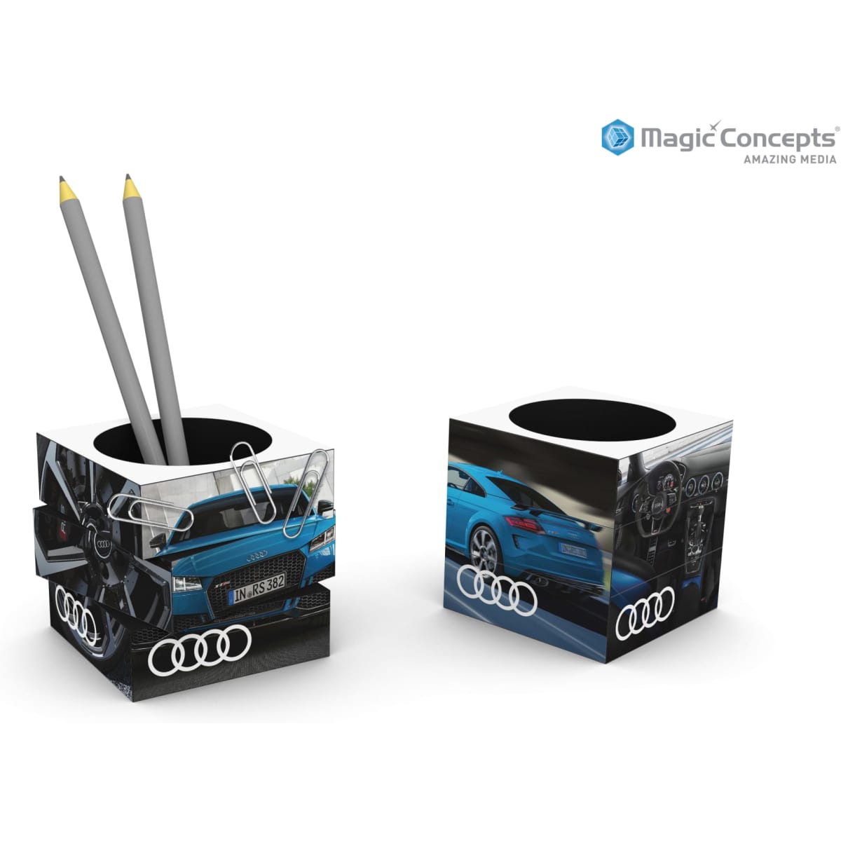 A cubic pen pot with a white and black design featuring images of a blue car and has a logo. Contains two grey pencils.