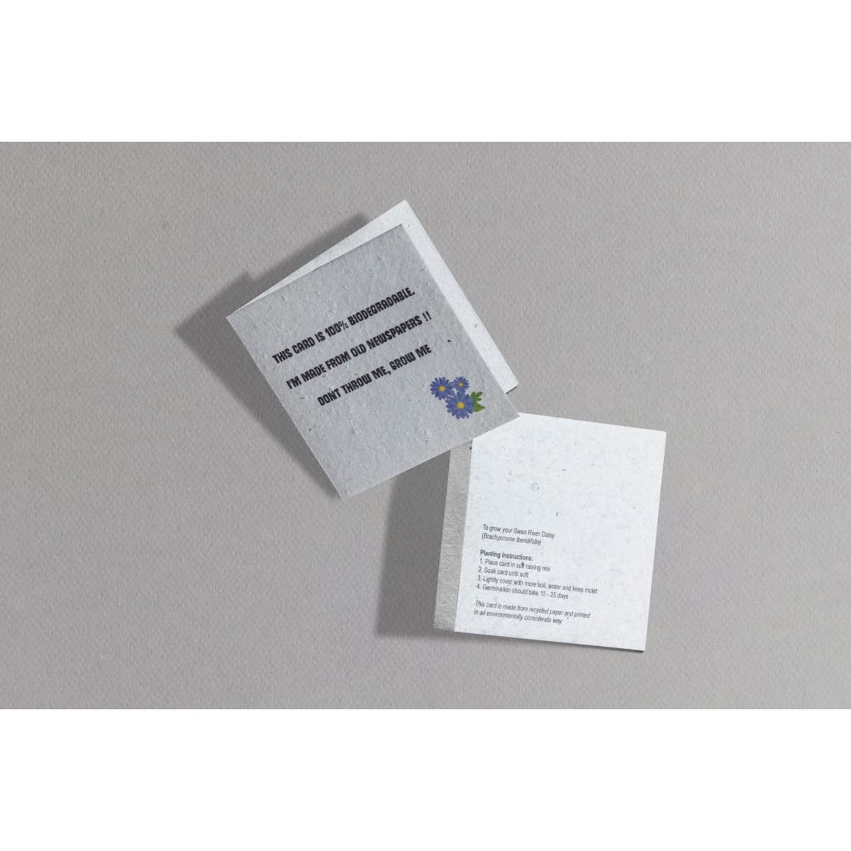 A small seed paper greeting card in grey with a floral design and text about planting. It has a logo on one side.