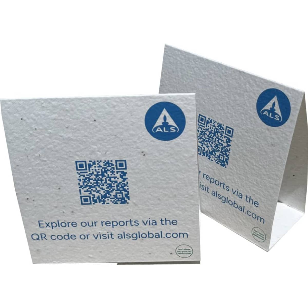 A white seed paper table tent card with a QR code and branding, featuring a textured surface with speckles.