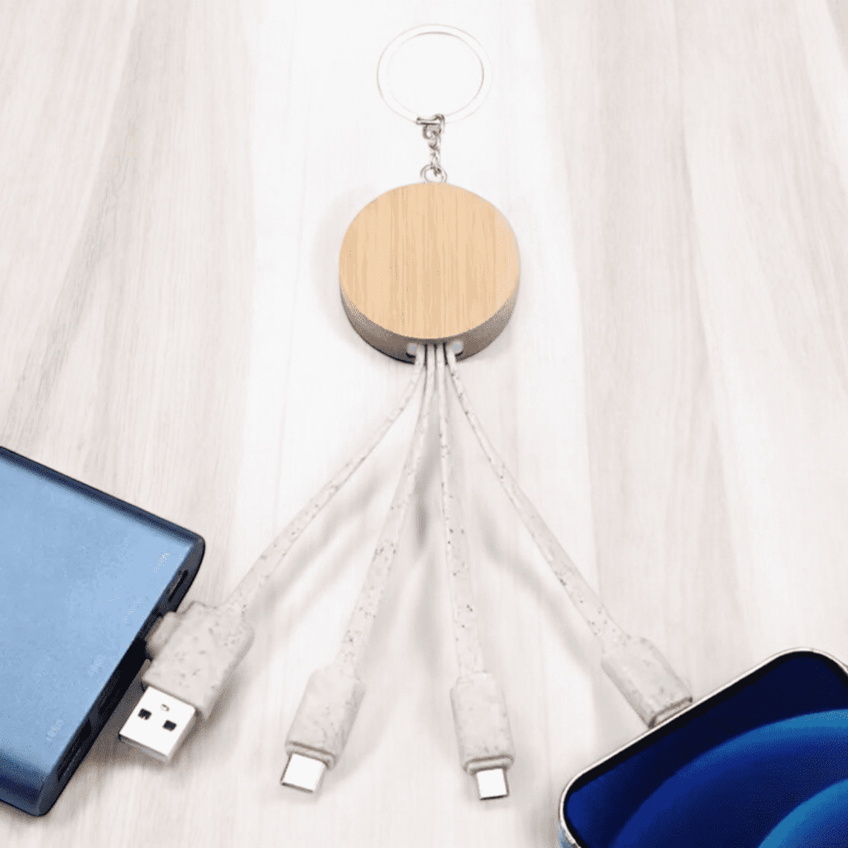A wooden multi cable charger with three connectors, including USB and USB-C, attached to a keyring.