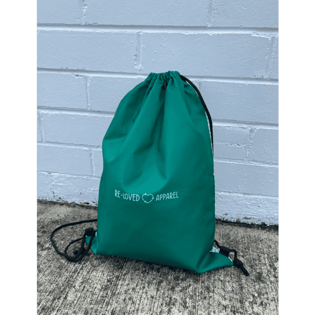A teal drawstring backpack made from rPET, featuring a logo on the front and black drawstrings.