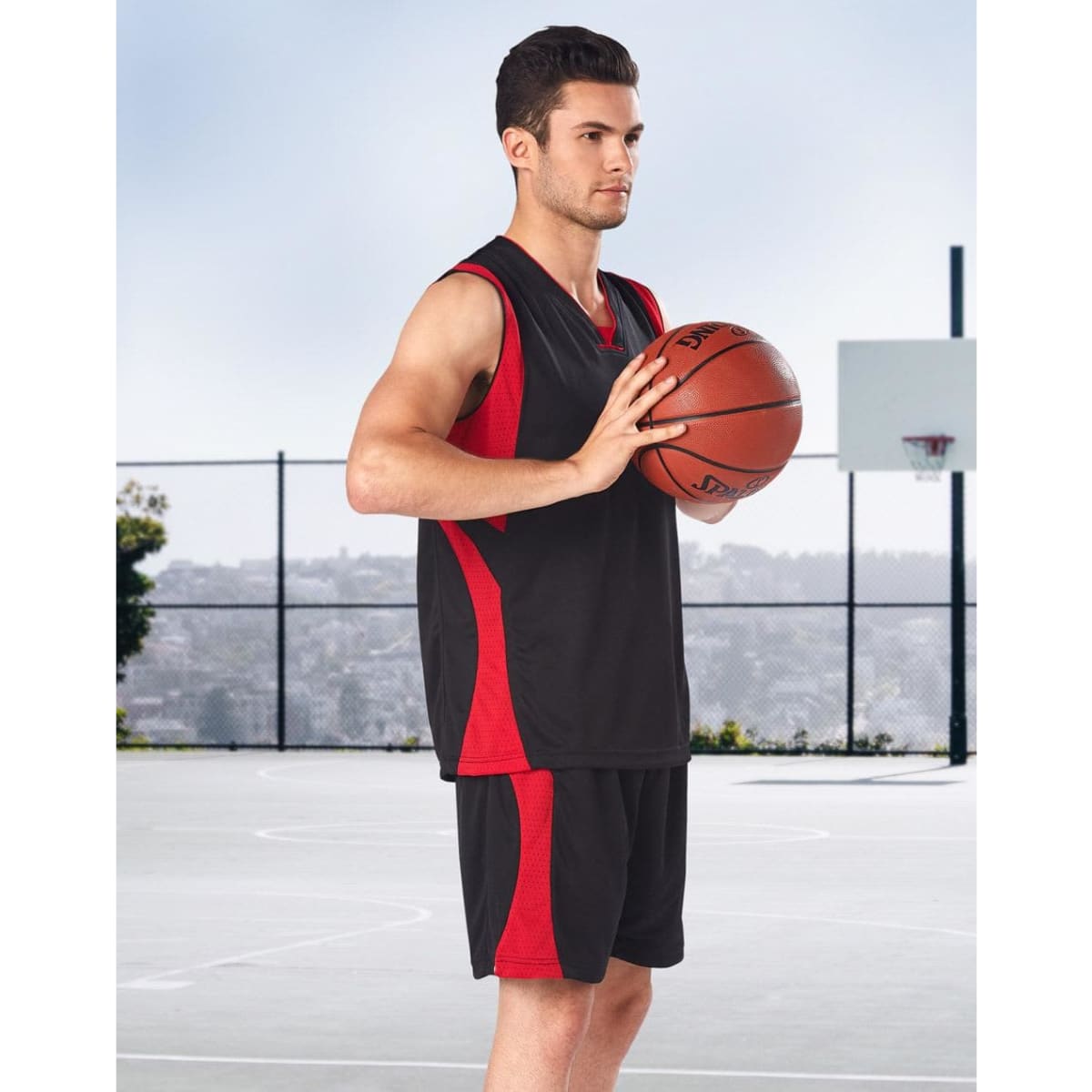 Adults' basketball shorts in black and red, featured with a player holding a basketball on a court.