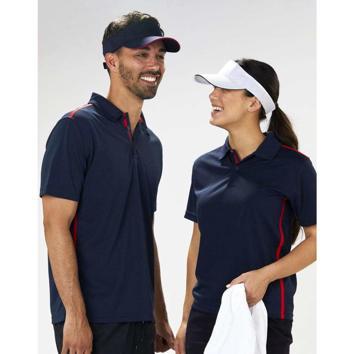 A navy visor with a contrasting white band, worn by a smiling man and woman in matching polo shirts.