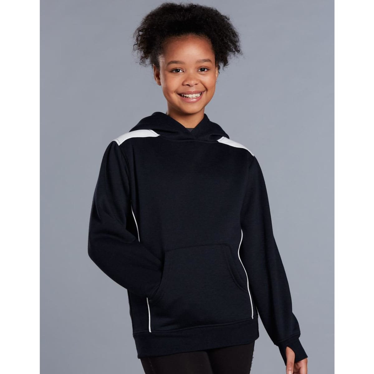 A young girl wearing a navy blue hoodie with white contrast detailing and a kangaroo pocket.