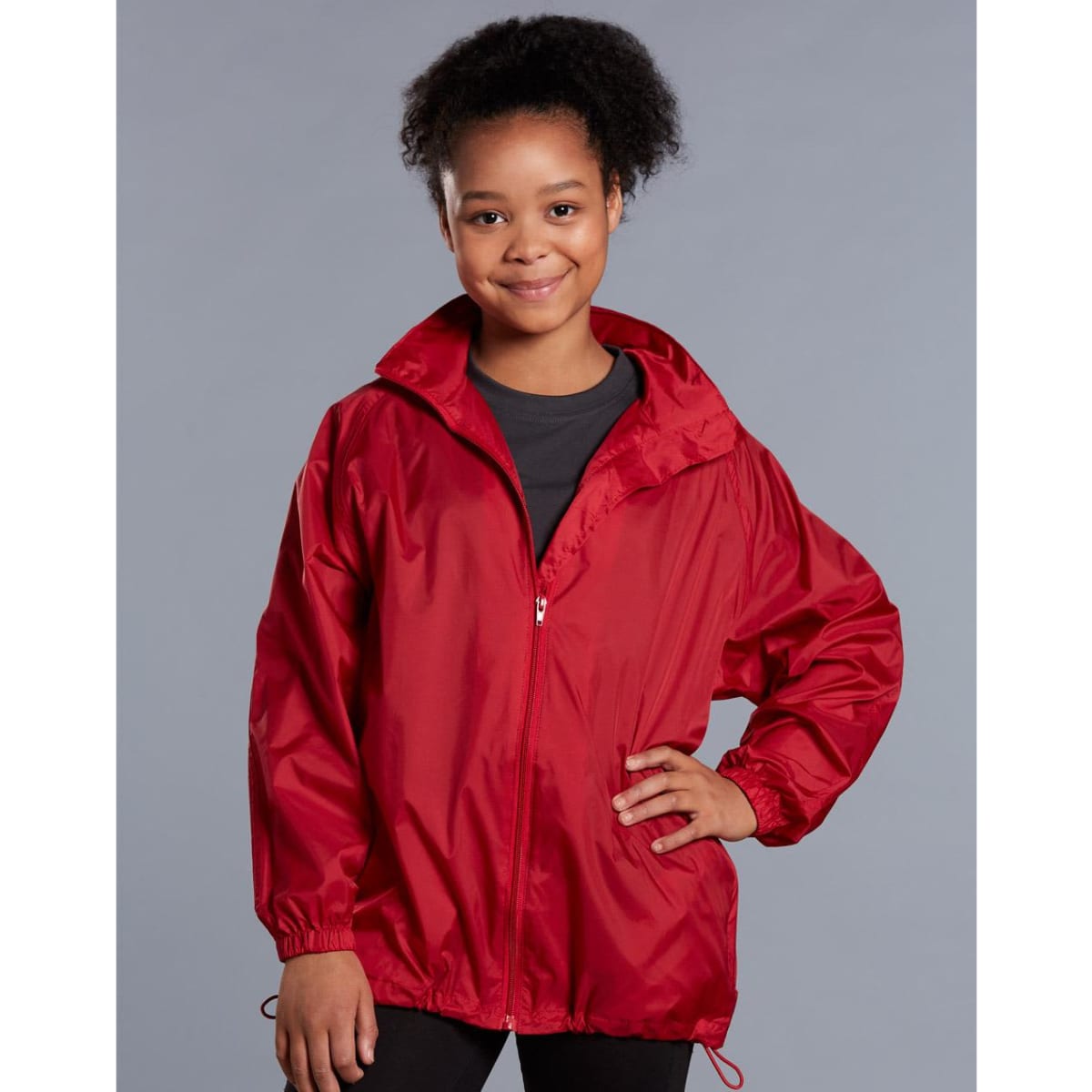 A red kids' outdoor activity spray jacket with a zipped front and elasticised cuffs, featuring a logo.