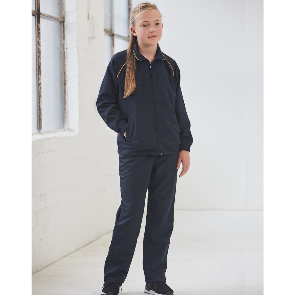 A navy track jacket featuring yellow accents, styled for kids, paired with matching trousers.