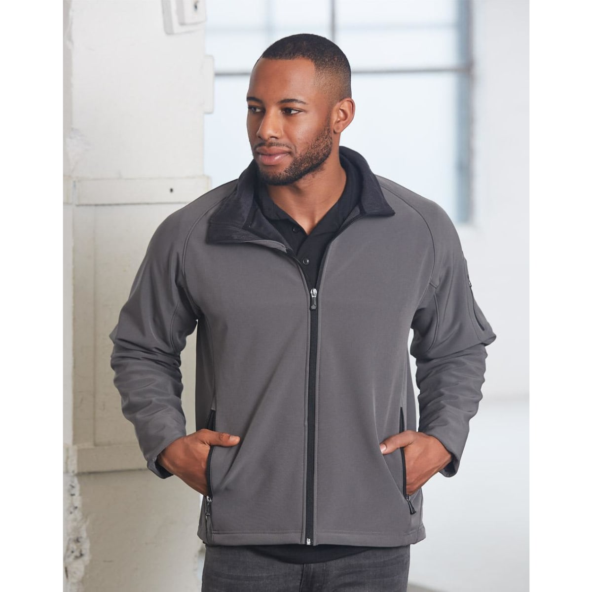 A men's softshell jacket in grey, featuring a zip-up front and side pockets, with a collar and branding.
