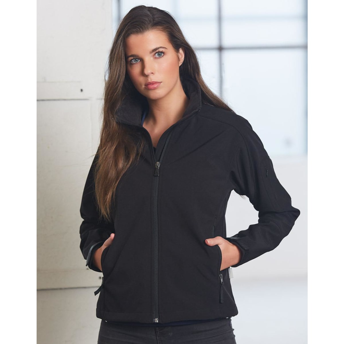 A black softshell jacket for ladies, featuring a zip front and side pockets, with a fitted design.