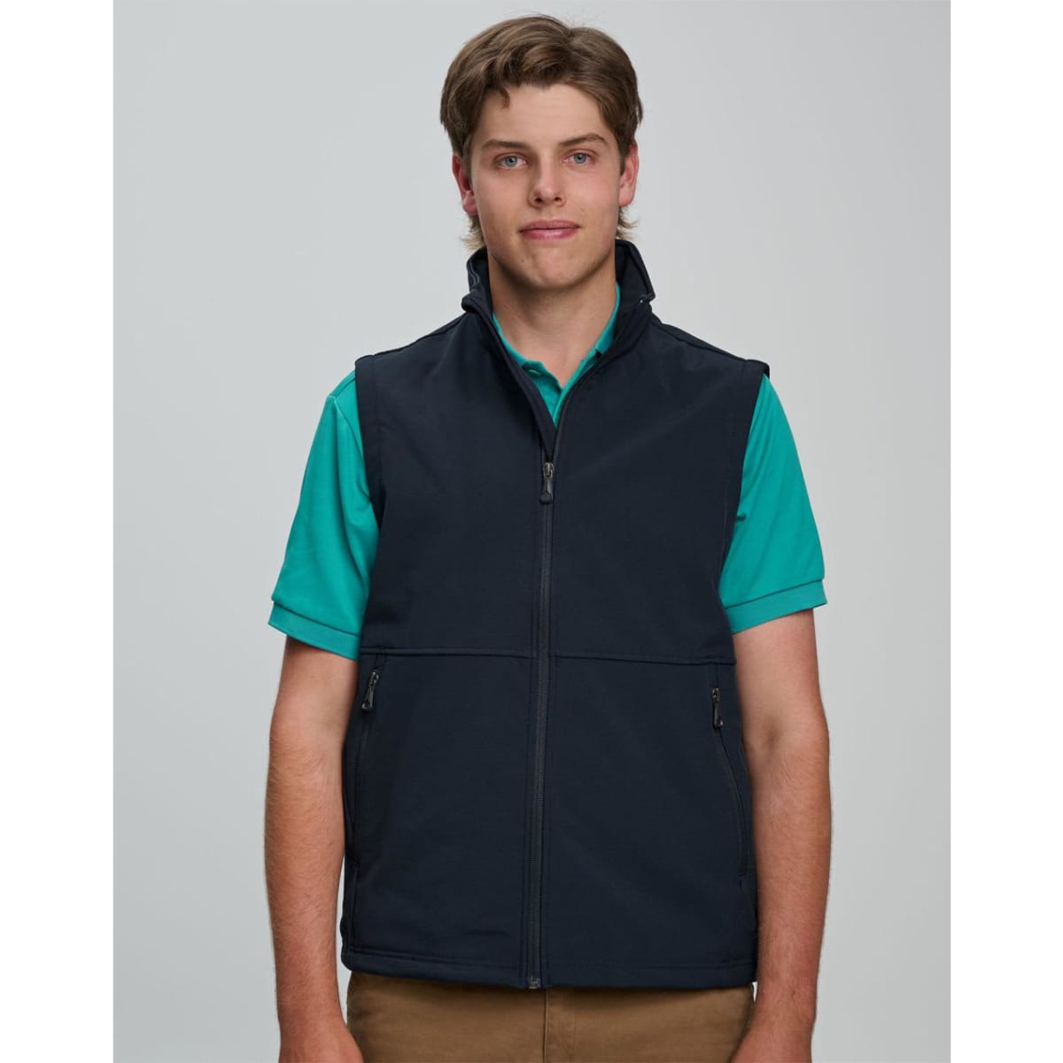 A men's softshell hi-tech vest in navy blue, featuring a zip front and side pockets, worn over a black t-shirt.