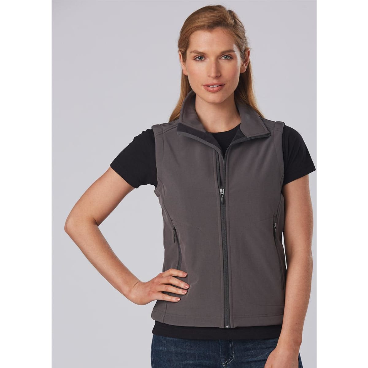 A grey ladies' softshell vest with a zip front and side pockets, worn over a black t-shirt. Features a logo.