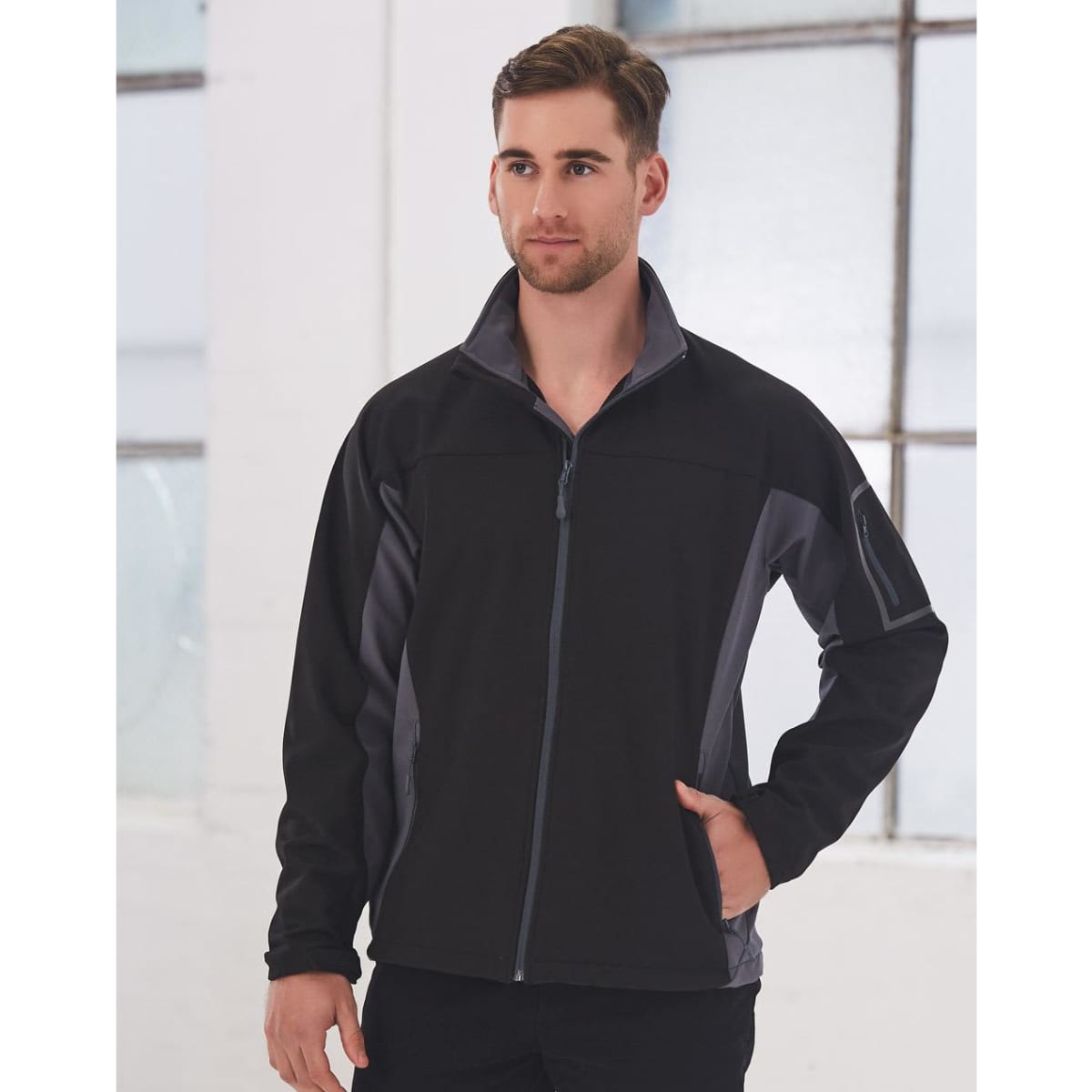 A men's softshell jacket in black with grey contrast panels, featuring a zip front and side pockets.