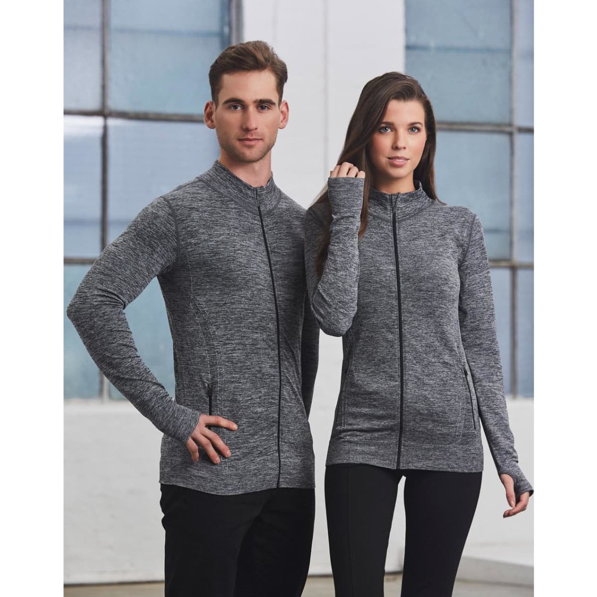 A unisex seamless heather jacket in grey, featuring a zip front and two models standing side by side.