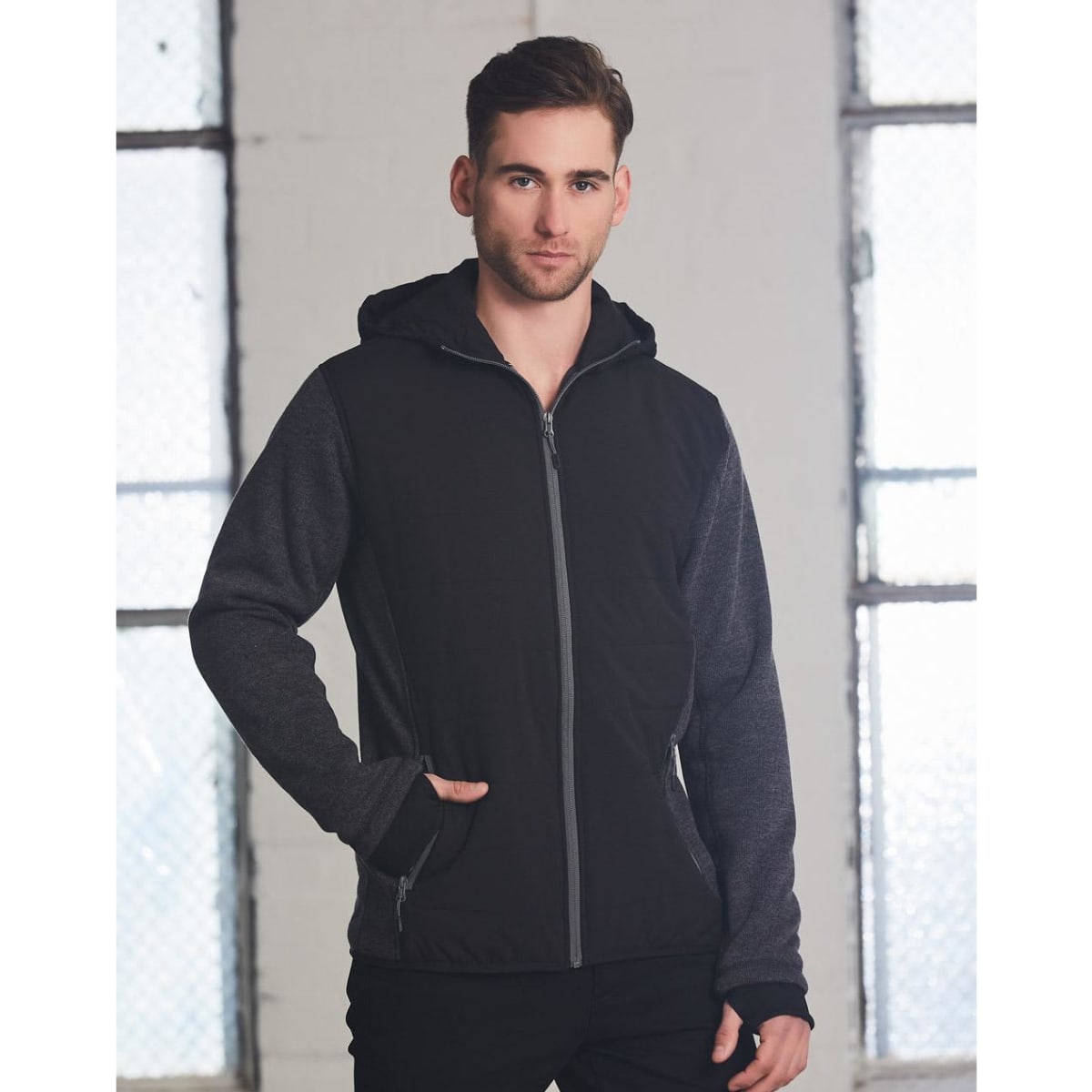 A men's jacket featuring a heather sleeve, quilted body, with a hood in black and grey tones. Includes a logo.