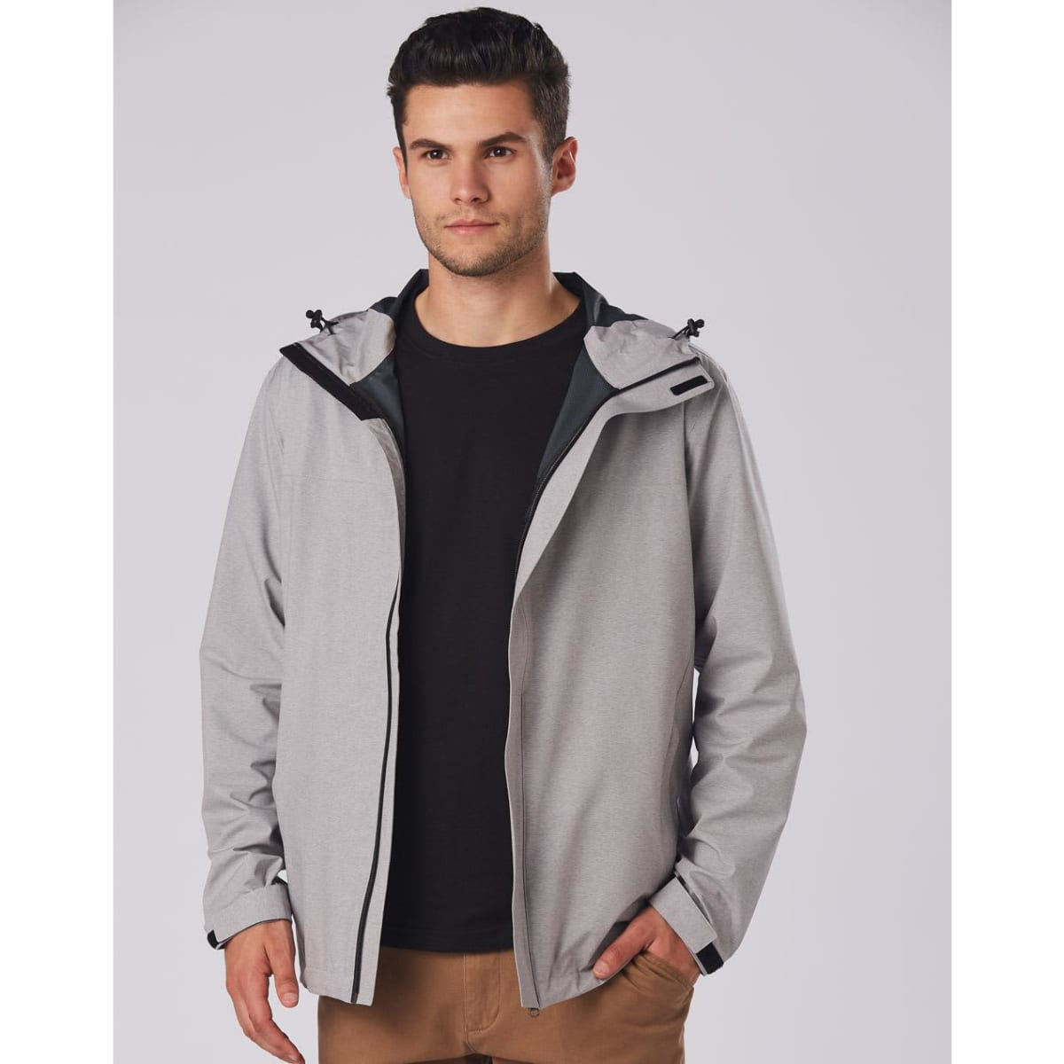 A grey waterproof performance jacket featuring a hood, worn by a model against a plain background.