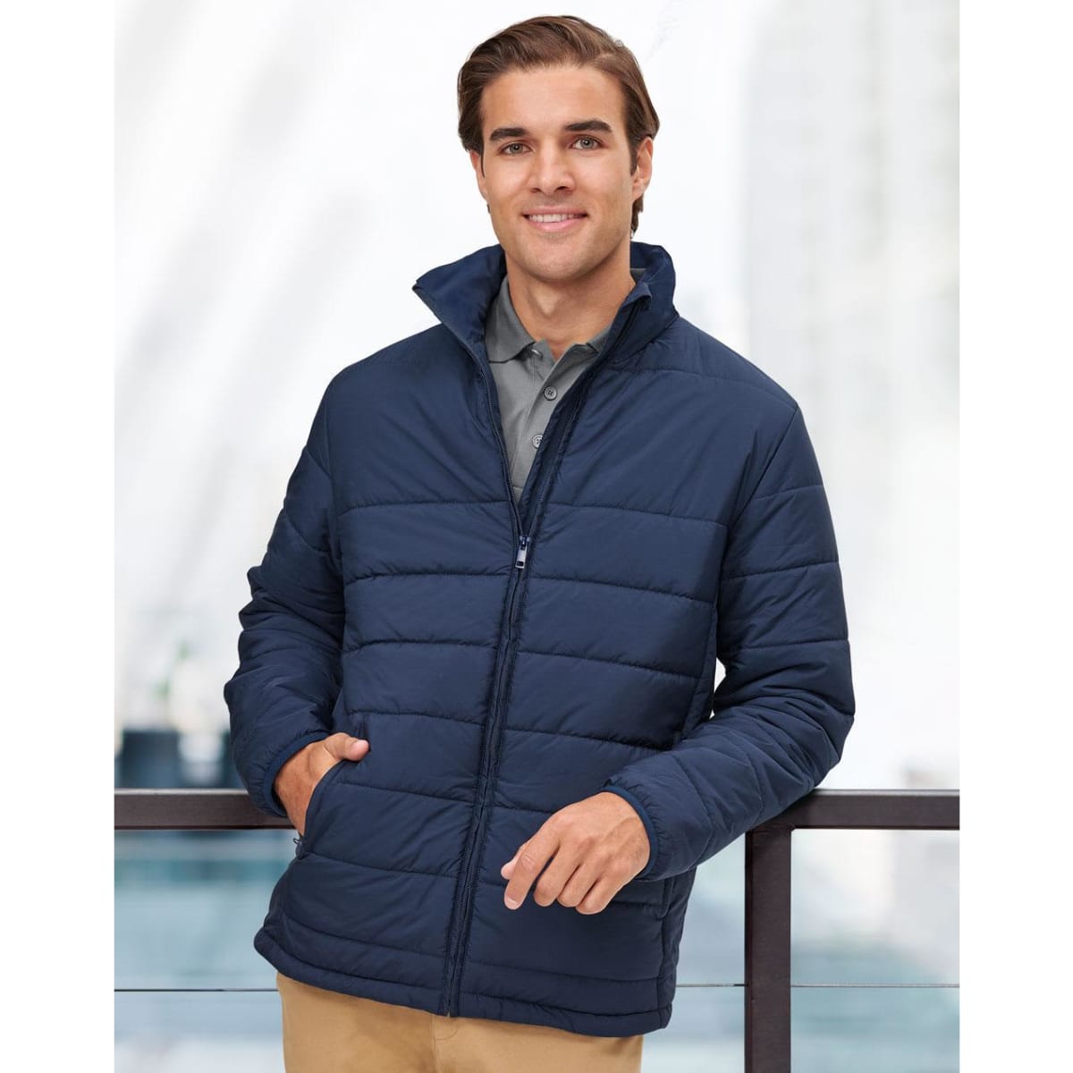 A navy insulated puffer jacket with a zip front and high collar, featuring a logo on the chest.