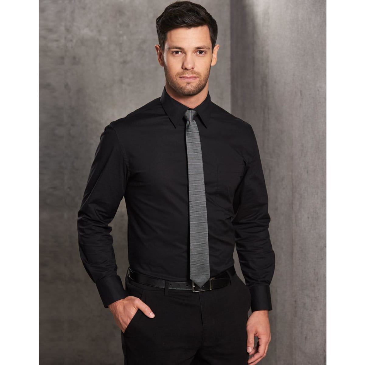 A man wears a black long-sleeve cotton/poly blend button-up shirt with a grey tie, featuring a chest pocket.