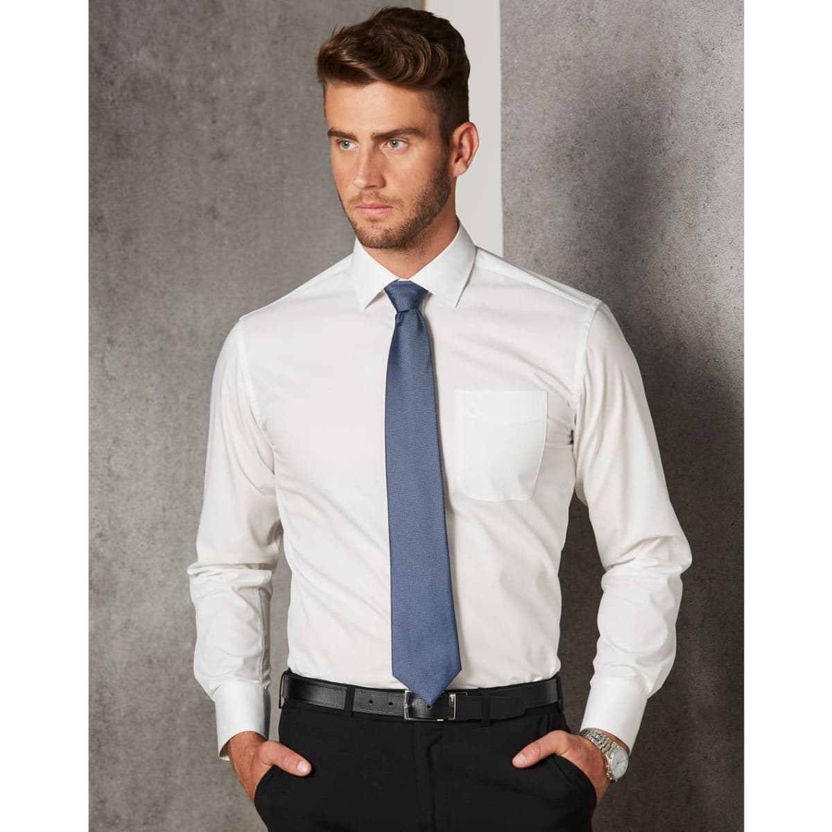 A men's long-sleeve button-up shirt in white with a pocket, paired with a dark tie and black trousers.