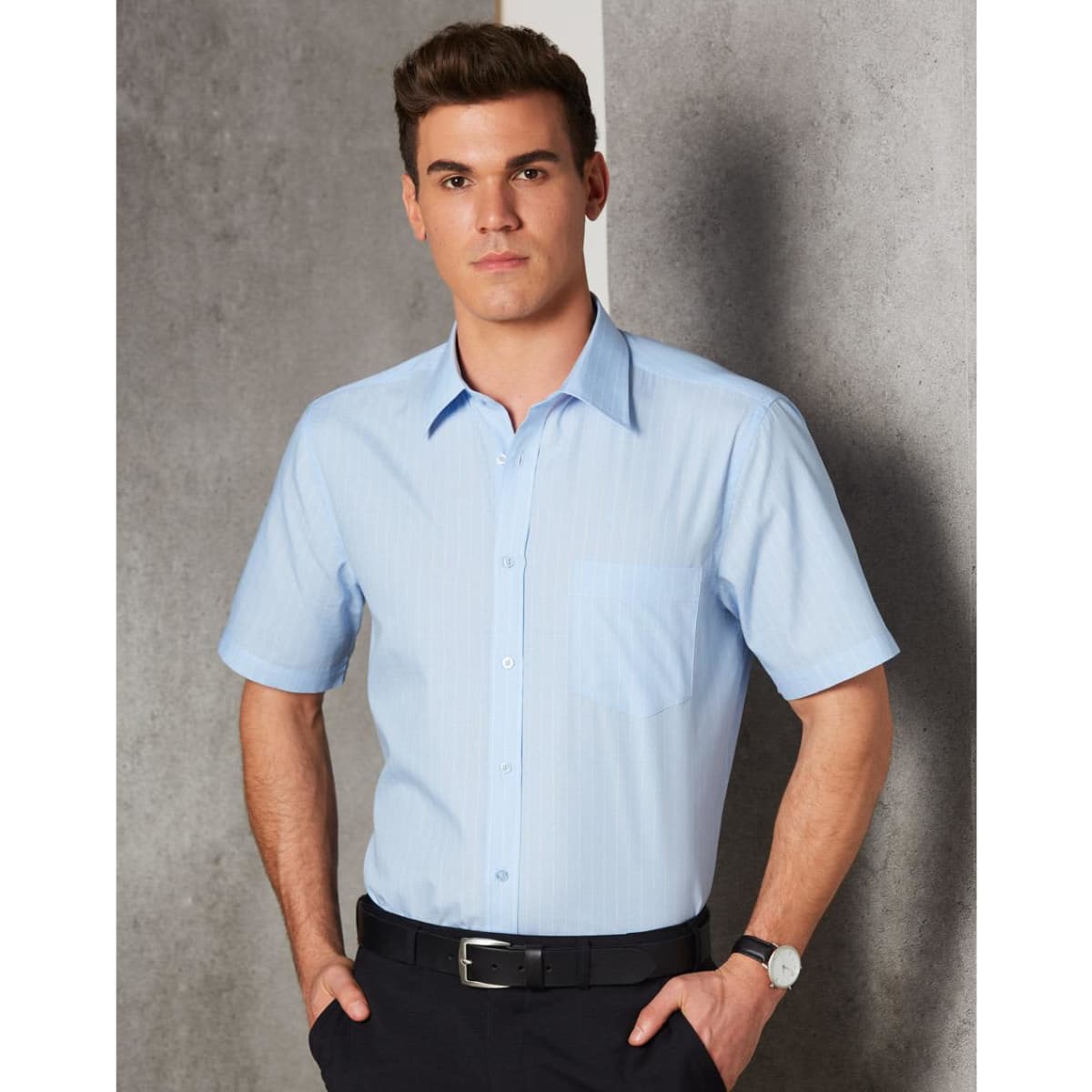 A light blue men's pin stripe short sleeve button-up shirt featuring a chest pocket and a logo.