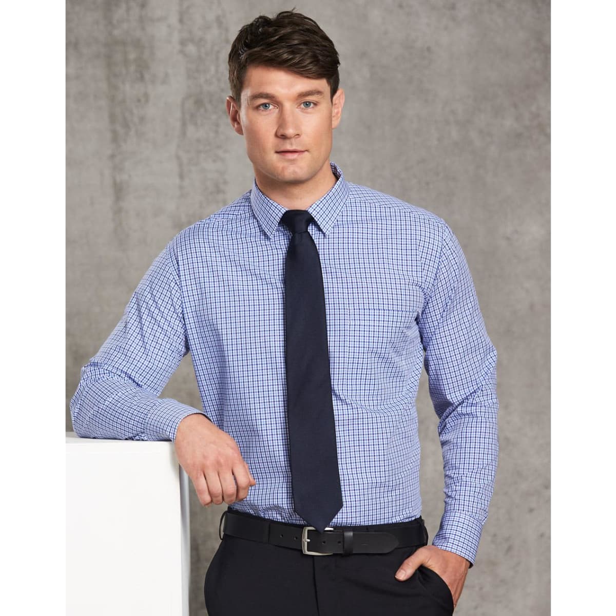 A two-tone blue and white check long-sleeve shirt displayed on a male model, featuring a dark tie and belt.