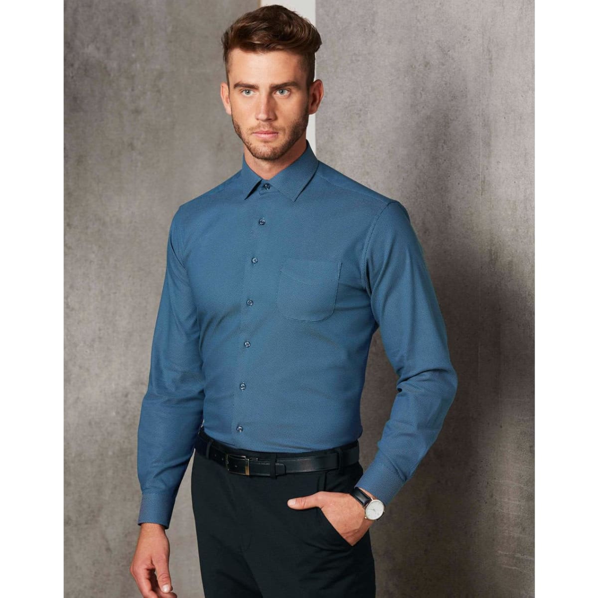 Men's pin dot stretch long-sleeve shirt in teal blue, featuring a collar and single chest pocket, with branding visible.