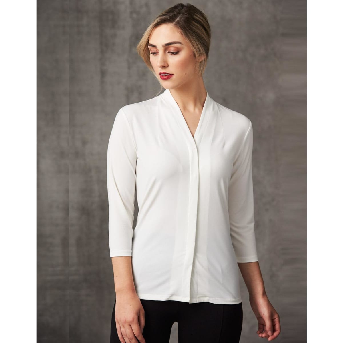 A white mid sleeve knit top with a shawl collar and fitted design, featuring subtle branding.