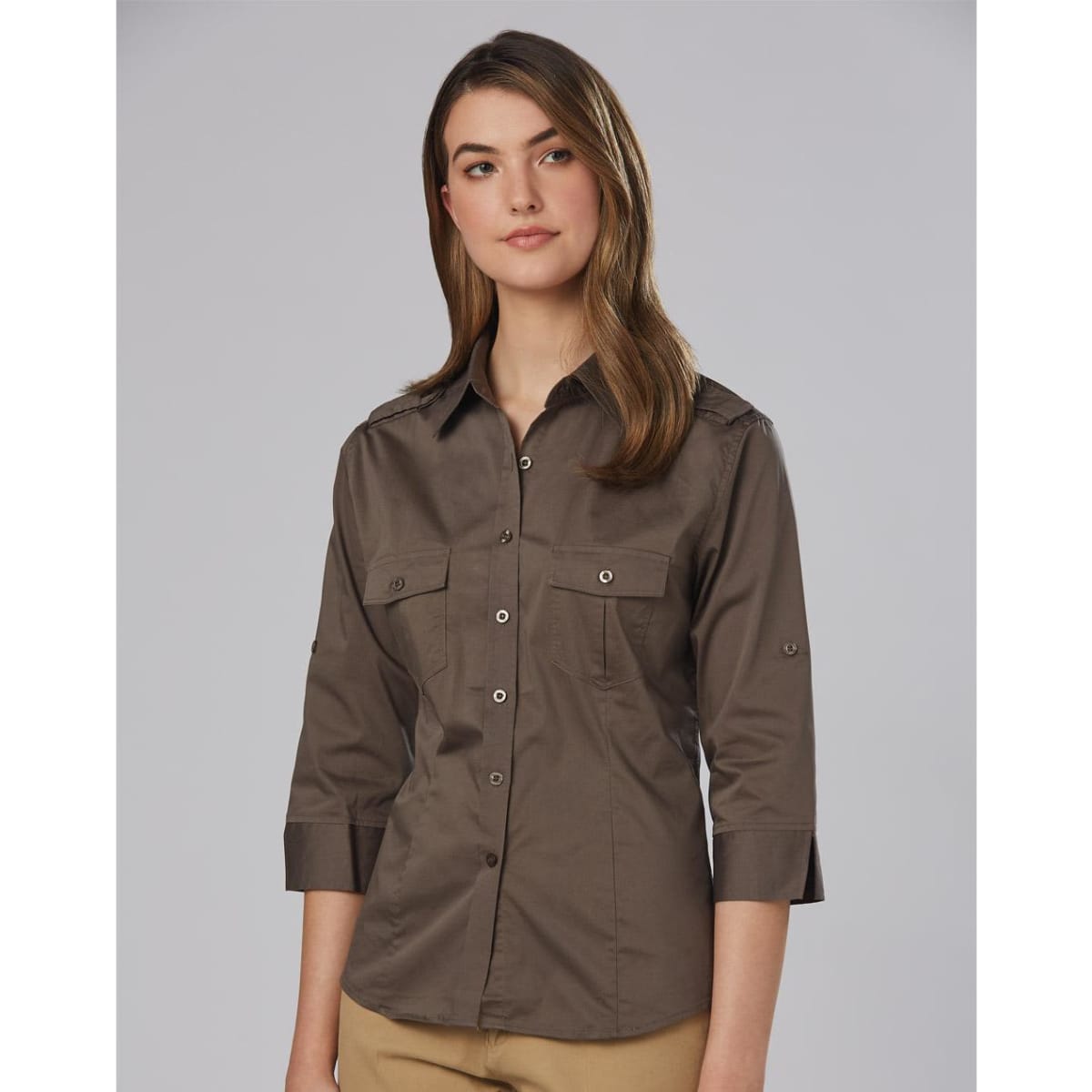 A women's military-style shirt in khaki with 3/4 sleeves and two front pockets, featuring a logo on the fabric.
