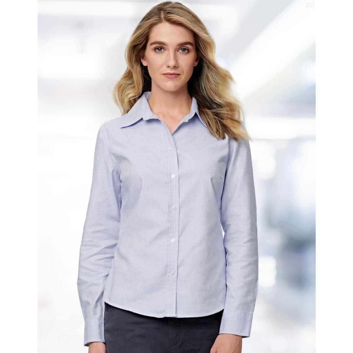A light blue long sleeve button-up shirt for ladies, featuring a classic collar and a subtle textured pattern.