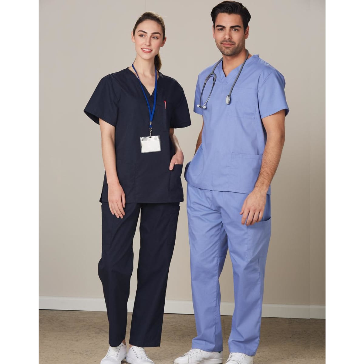 Unisex scrub pants in navy blue, worn by a male and female model, featuring a logo on the garment.