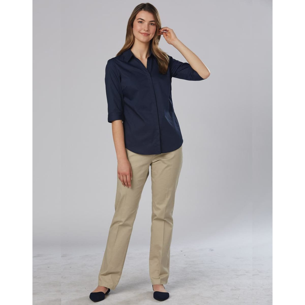 A woman wearing navy and khaki women's chino pants, styled for a casual look with a collared shirt.