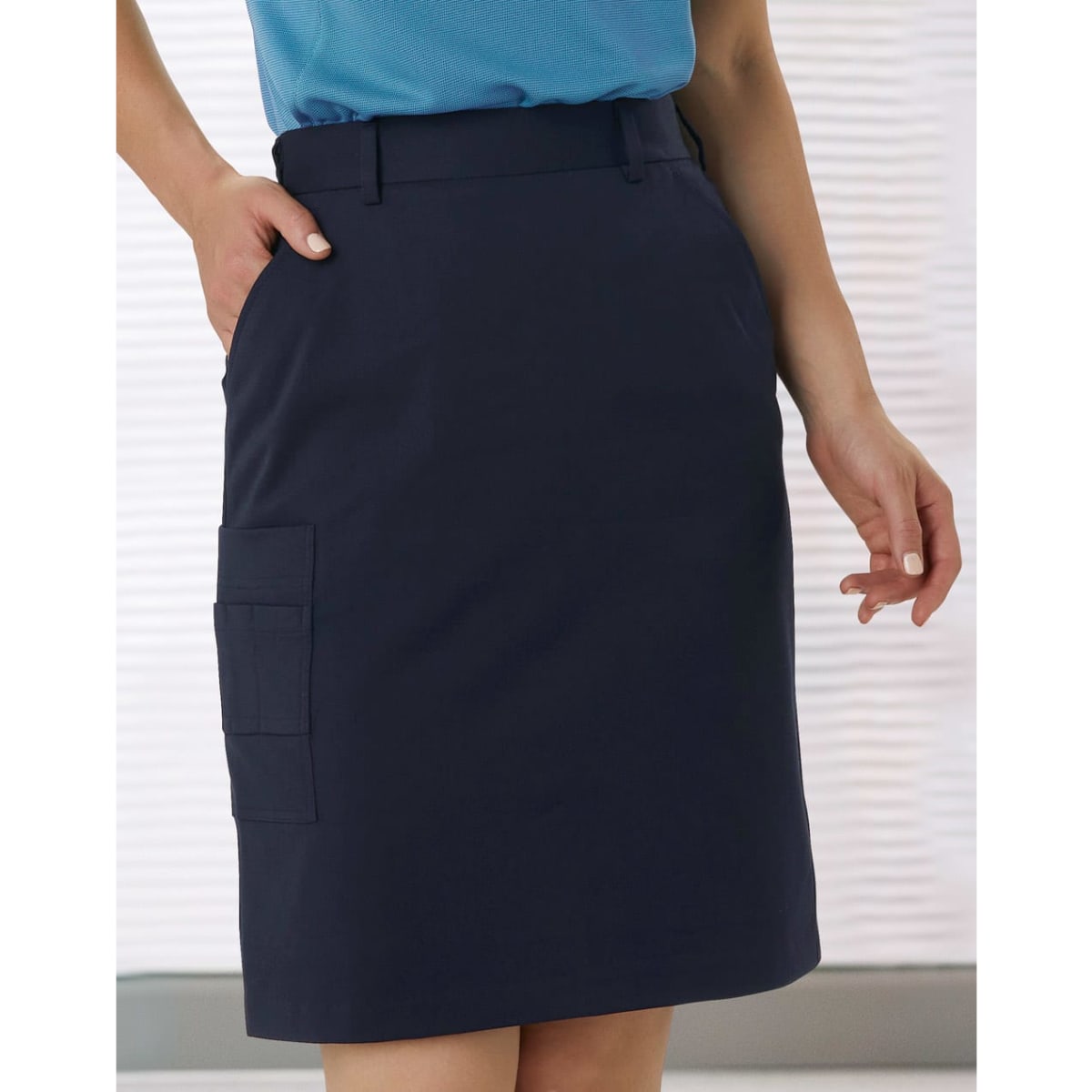 A navy utility cargo skirt featuring a side pocket and a fitted design, paired with a blue top.