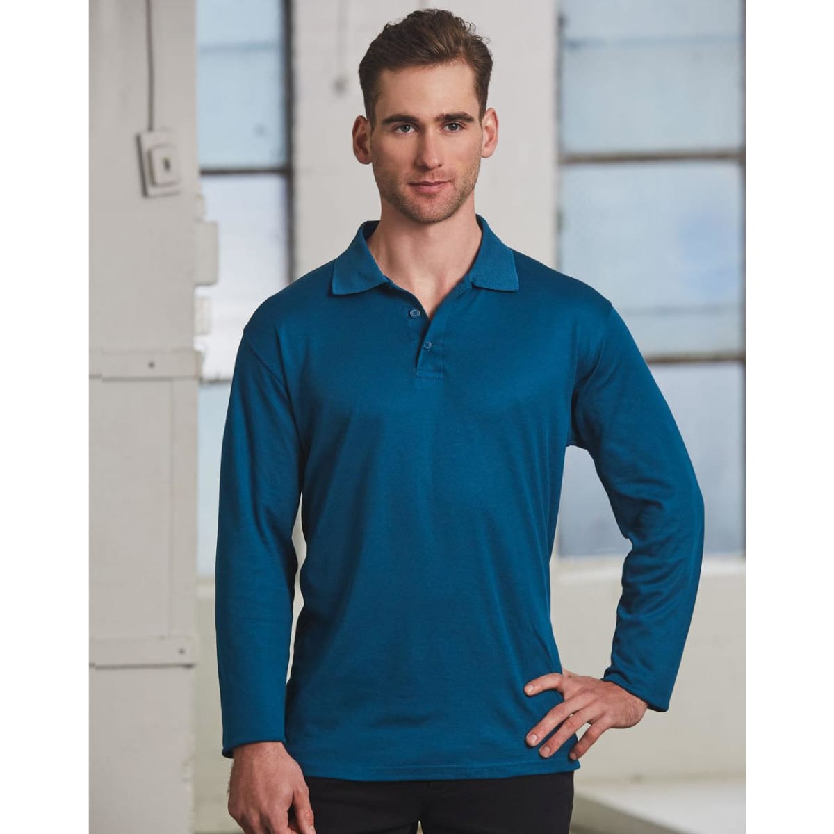 A long sleeve polo shirt in a rich teal colour, featuring a collar and a logo.