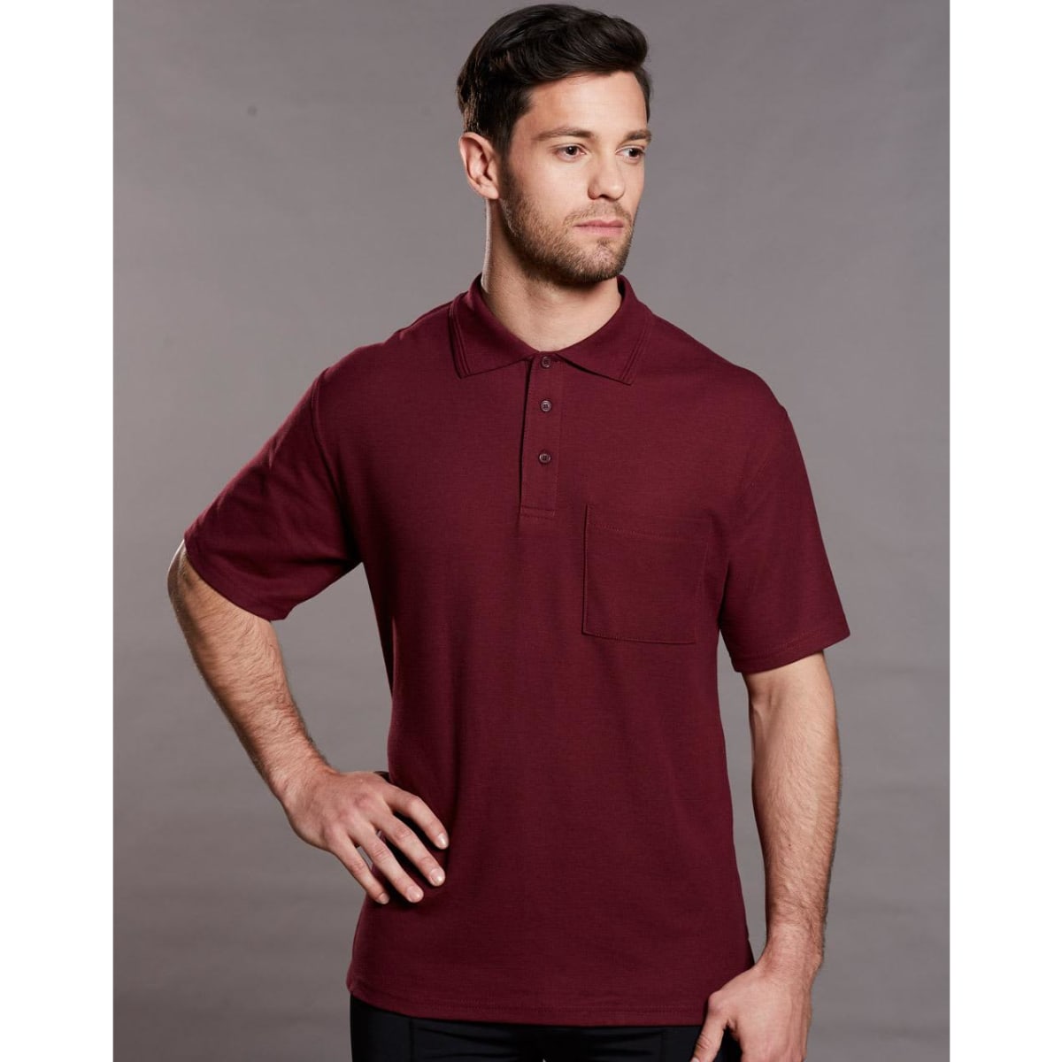 A maroon short sleeve polo shirt with a pocket and a logo on the chest.