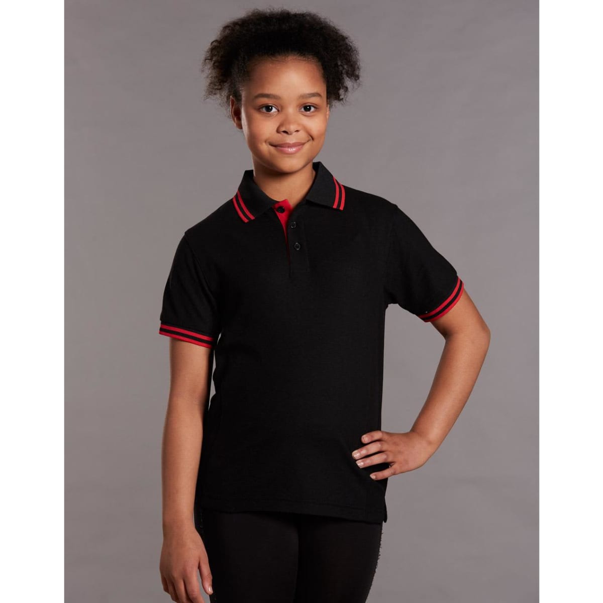 A black kids' polo shirt featuring red collar and sleeve trims, displaying a logo.