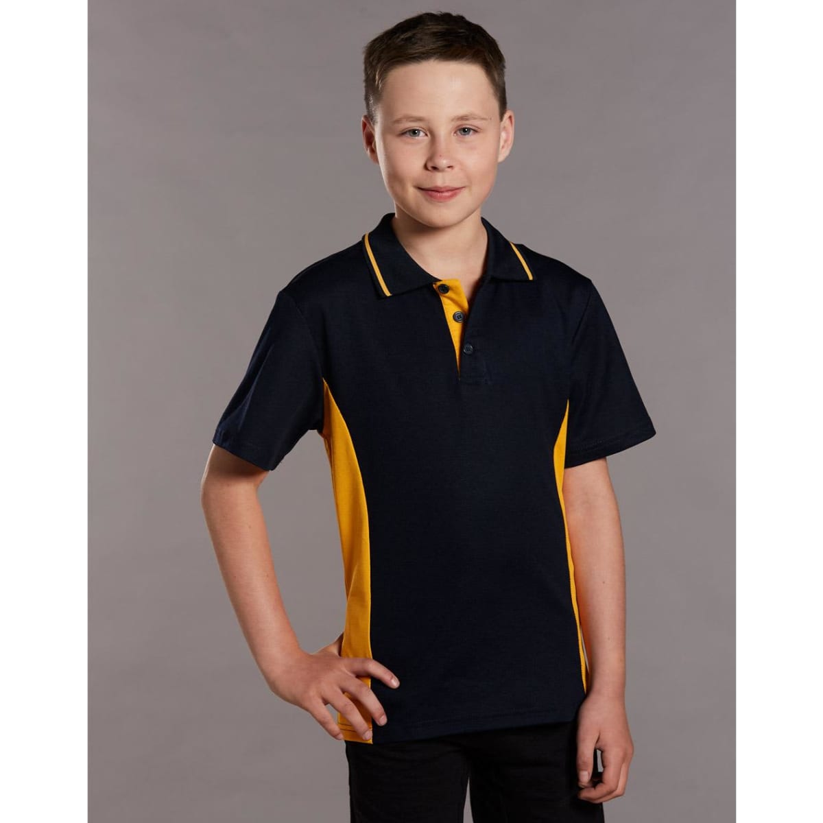 A young boy models a navy and gold contrast polo shirt, featuring a classic collar and a logo.