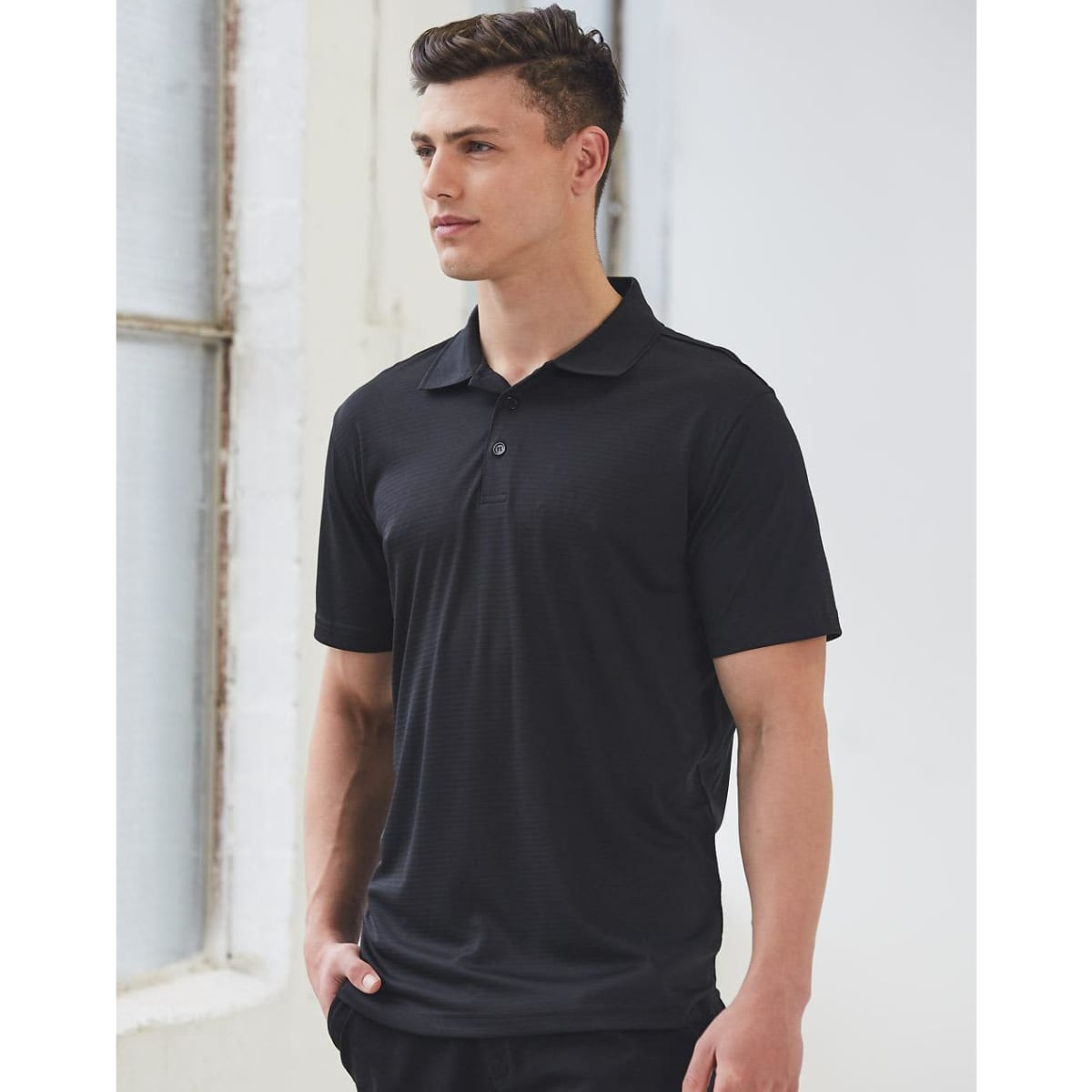 A black textured polo shirt featuring a collar and short sleeves, along with a logo on the chest.